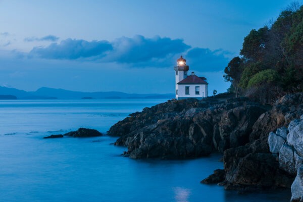 lighthouse sitting on top of a rocky shore
