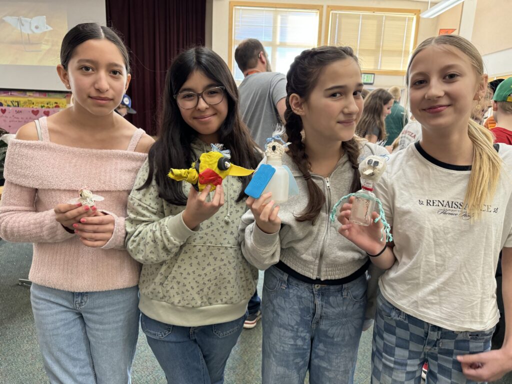 four girls holding their finished art projects