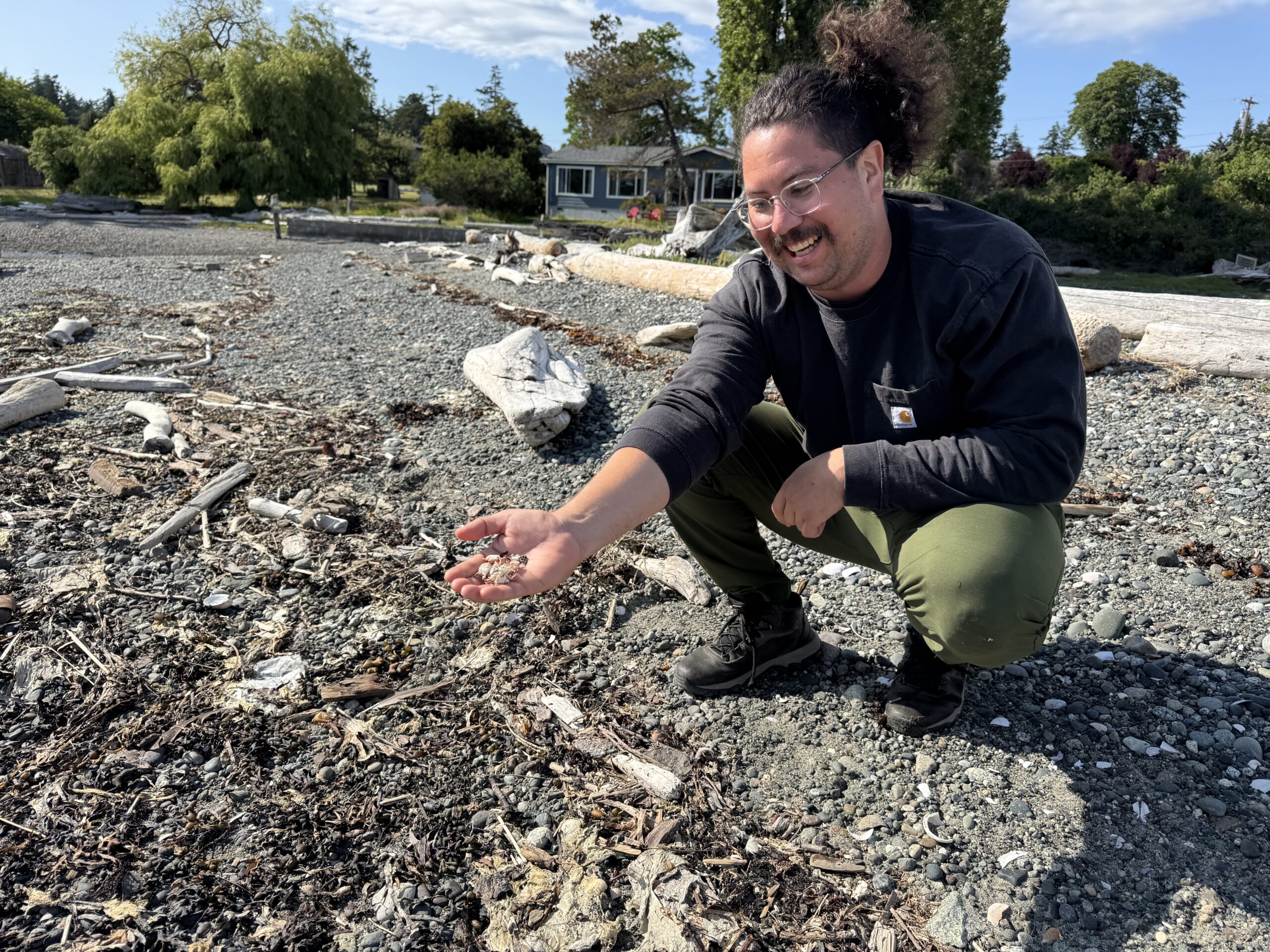 volunteer looking at soil on a beach