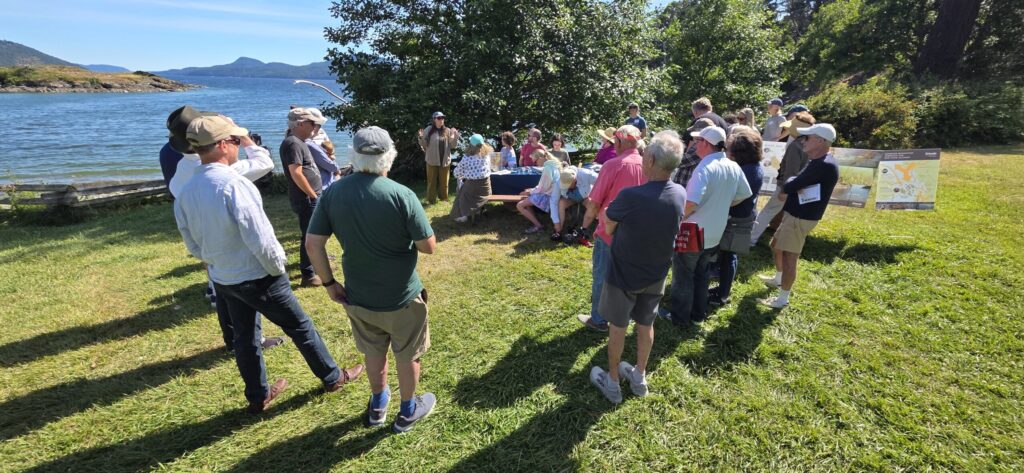 group of people standing on an island listening to a demonstration