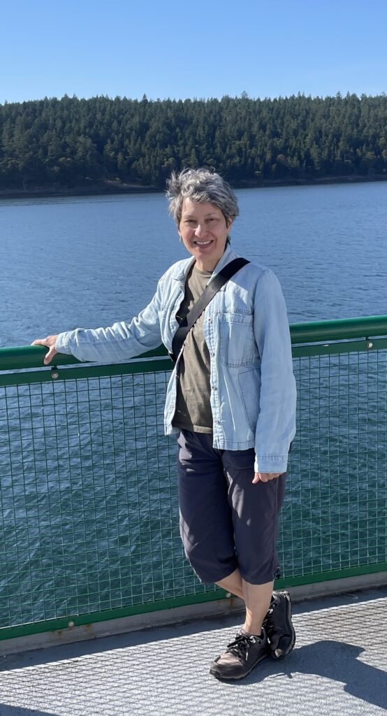 lori with a hand on the railing with the islands in the background