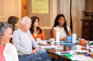 people sitting at a table discussing topics in a meeting